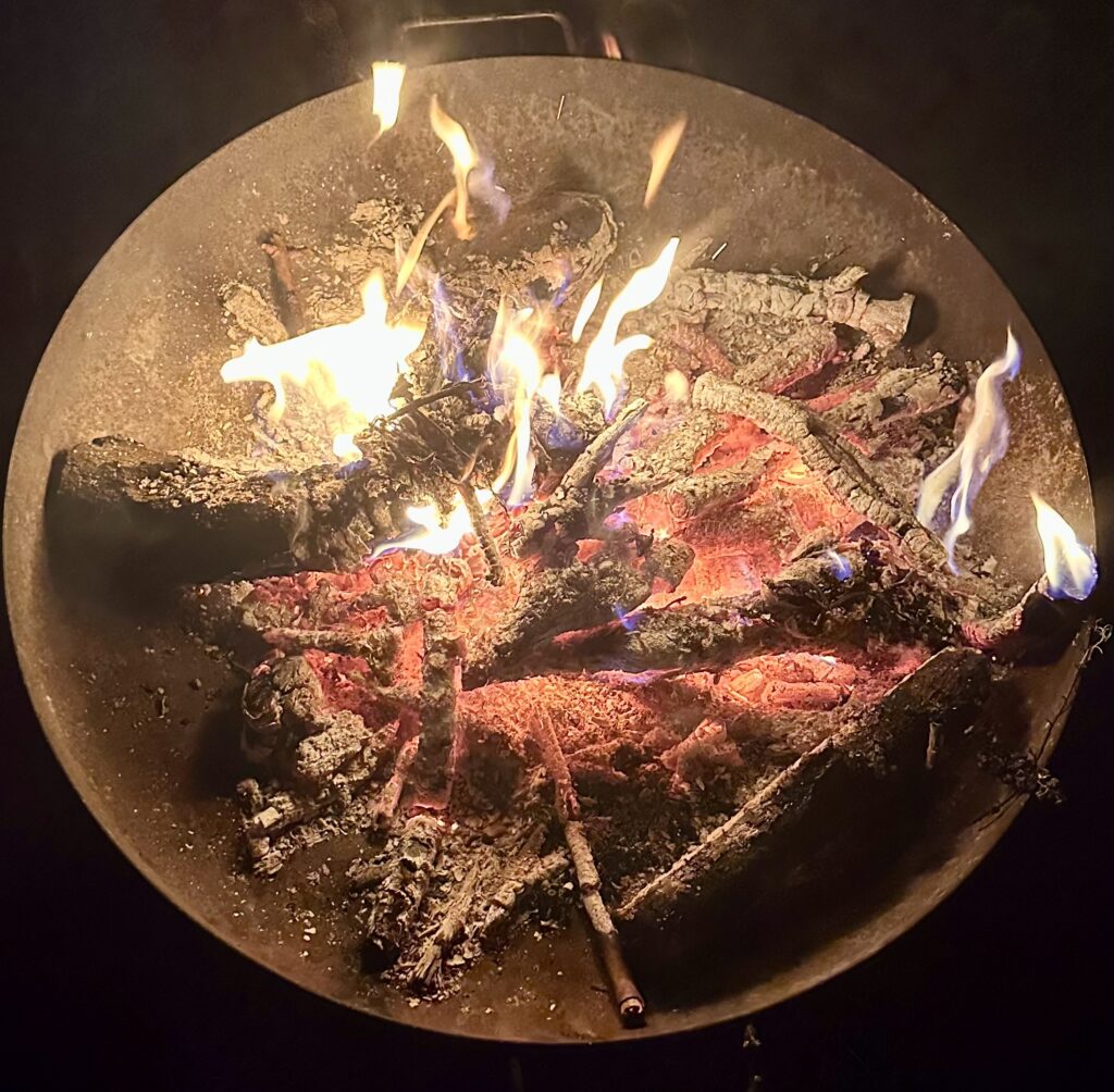 Feu de bois dans un brasero, évoquant la dimension énergétique des soins