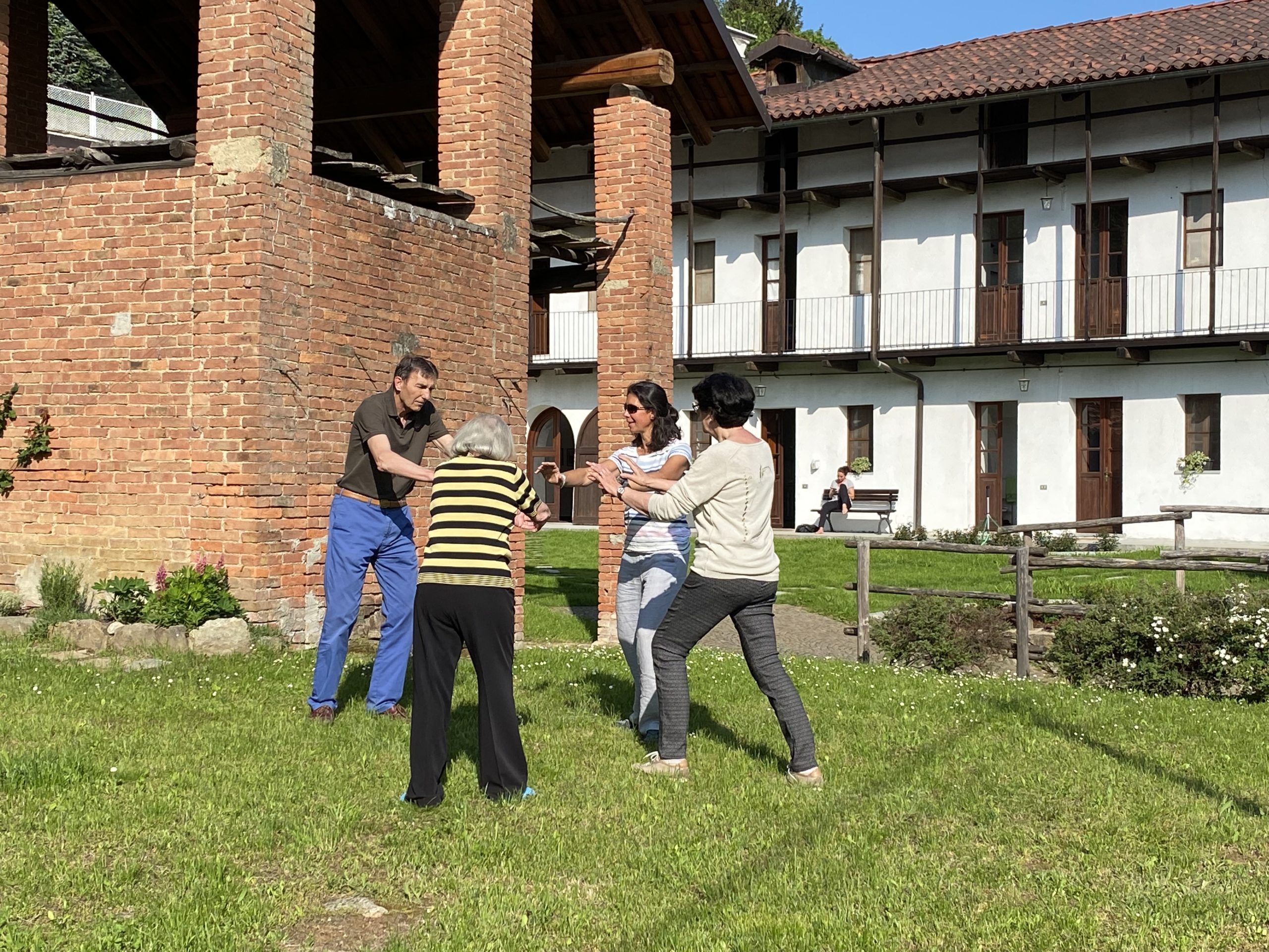 Groupe d’adultes en activité conviviale dans un jardin de bâtiments historiques