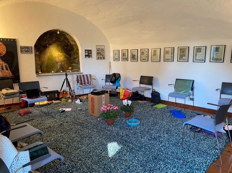 Salle d’atelier chaleureuse avec chaises en cercle, tapis, coussins et plantes
