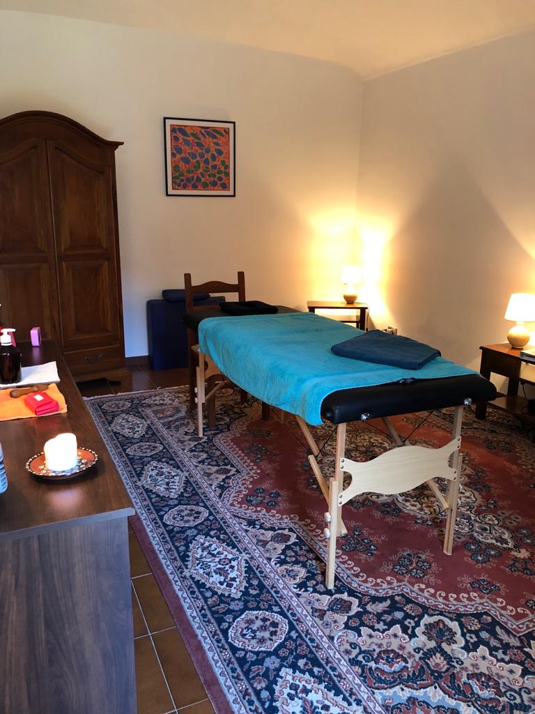 Salle de massage zen avec table turquoise, tapis oriental et lumière chaleureuse