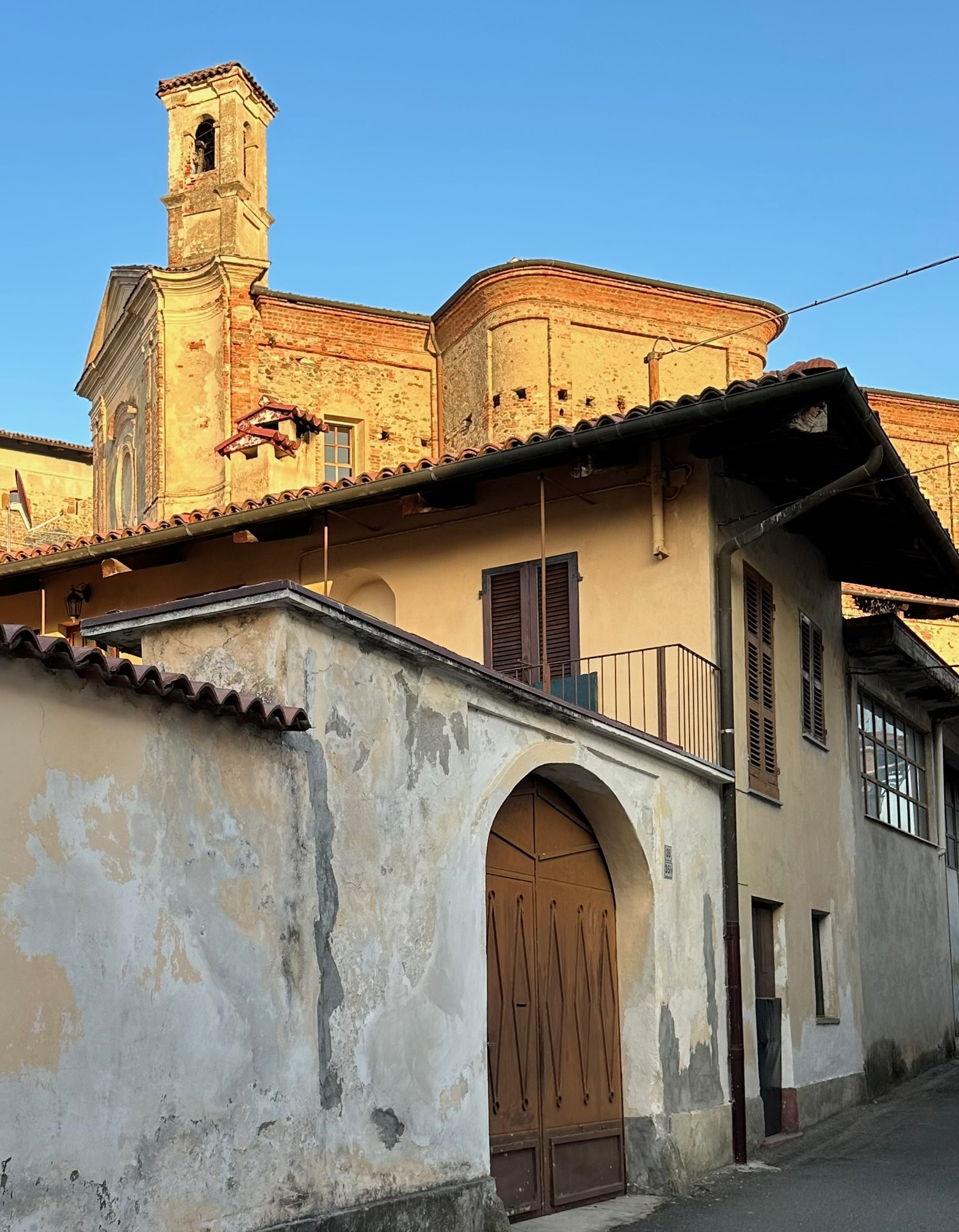 Vieille rue de village avec clocher de brique au coucher du soleil